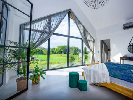grande baie vitrée double ouverture avec survitrage trapèze dans une chambre moderne